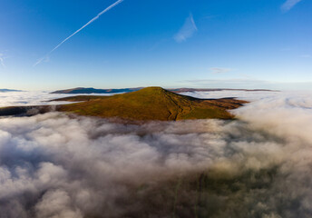 Aerial view of the Sugar Loaf mountain in the Brecon Beacons rising above a sea of cloud and fog
