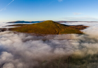 Aerial view of the Sugar Loaf mountain in the Brecon Beacons rising above a sea of cloud and fog