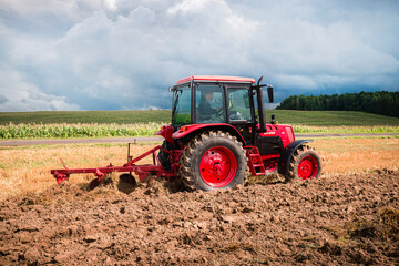 Obraz premium Farmer in tractor preparing land for sowing, plowing the field