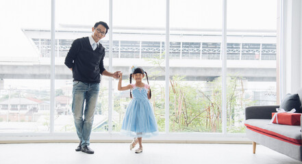 Father is teaching his little daughter to dance in the halls of the house. Happy holidays, family relationships.