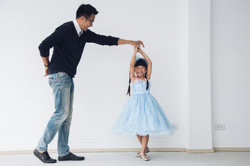 Father is teaching his little daughter to dance in the halls of the house. Happy holidays, family...