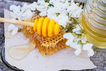 Naklejka premium Honey in jar with acacia flowers on rustic wooden background. Golden, fresh.