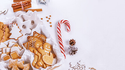 Top view of unpacked christmas present with sweets on a white textured surface, close-up. Christmas celebration concept with space for text