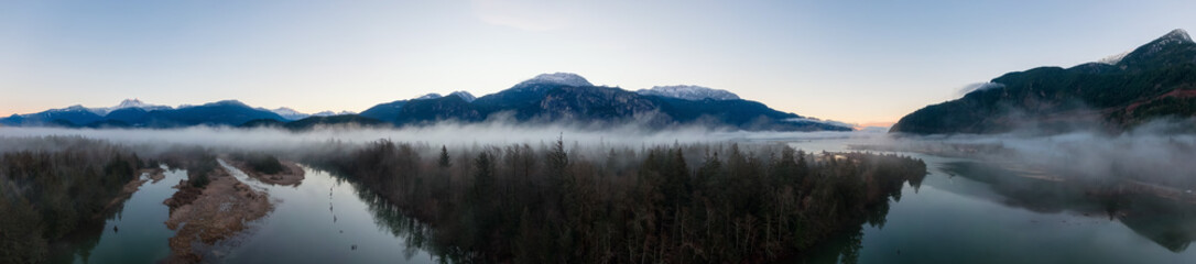 Aerial Panoramic Canadian Nature Landscape with mountains in background. Sunny Sunrise Sky. Taken in Squamish, North of Vancouver, British Columbia, Canada.