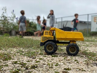 Children at Play with Yellow Dump Truck Toy