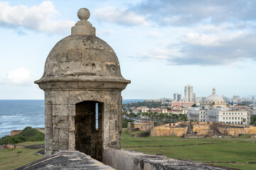 Turret at Castillo San Cristobal Fort with city in background at sunset in San Juan, Puerto Rico....