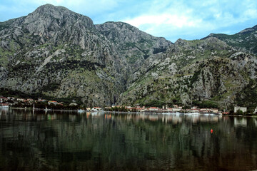 Bay of Kotor, also known as Kotorska Boka, during a quiet summer evening with mountains reflecting in the waters of the Adriatic sea.