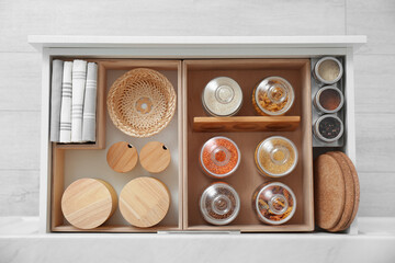 Open drawer with different jars indoors, top view. Order in kitchen