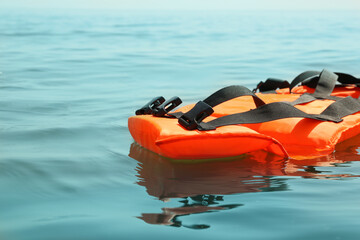 Orange life jacket floating in sea. Emergency rescue equipment