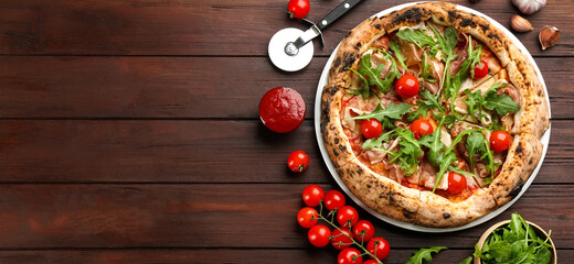 Tasty pizza with meat and arugula on wooden table, flat lay. Space for text