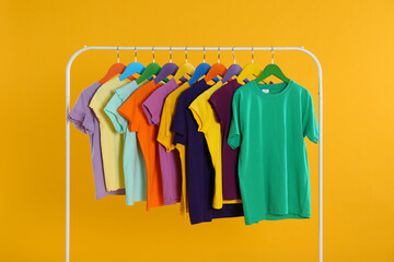 Obraz premium Rack with stylish children clothes on yellow background