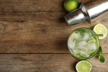 Delicious mojito and ingredients on wooden table, flat lay. Space for text