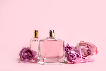 Bottles of perfume and beautiful roses on pink background - obrazy, fototapety, plakaty