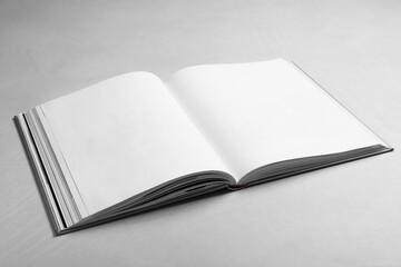 Open book with hard cover on light grey table