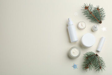 Flat lay composition with different cosmetic products on beige background, space for text. Winter care