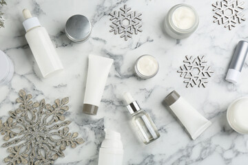Flat lay composition with different cosmetic products on white marble table. Winter care