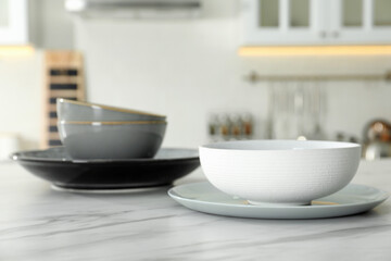 Fototapeta na wymiar Set of ceramic tableware on white marble table in kitchen
