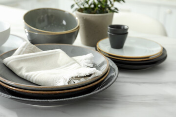 Set of beautiful ceramic tableware on white table in kitchen. Space for text