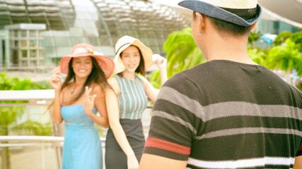 Naklejka premium Three asian young friends enjoy outdoor time taking pictures along the city streets