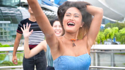 Three asian young friends enjoy outdoor time taking selfies along the city streets