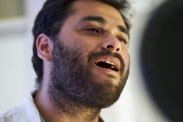 Obraz premium close-up of musician singing softly in front of the microphone