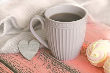 Cozy stiil life with cup of coffee, warm plaid,  heart and marshmallow. pink wooden background. Haze vintage filter and soft focus.   Happy Valentine's Day