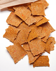 Raw organic chips on a white background made from sun dried tomatoes and various seeds then baked in a dehydrator