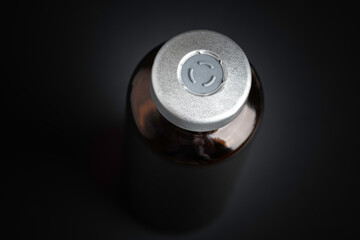Macro Image Of Amber Vaccine Vial In Black Background