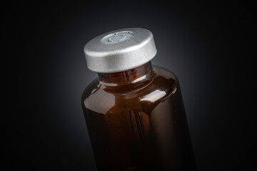 Macro Image Of Amber Vaccine Vial In Black Background