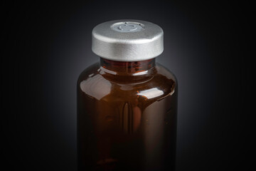 Macro Image Of Amber Vaccine Vial In Black Background