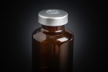Macro Image Of Amber Vaccine Vial In Black Background