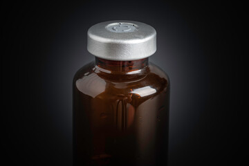 Macro Image Of Amber Vaccine Vial In Black Background