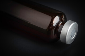 Macro Image Of Amber Vaccine Vial In Black Background
