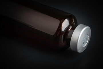 Macro Image Of Amber Vaccine Vial In Black Background
