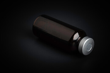 Macro Image Of Amber Vaccine Vial In Black Background