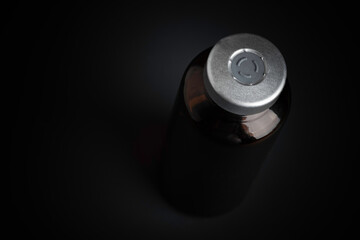 Macro Image Of Amber Vaccine Vial In Black Background
