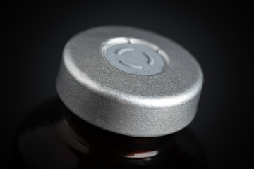 Macro Image Of Amber Vaccine Vial In Black Background