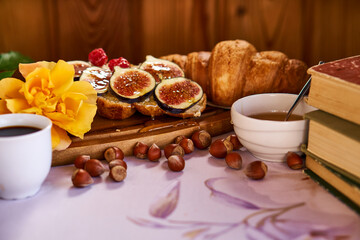 Coffee and croissant for Breakfast. French toast with figs near a yellow rose. High quality photo