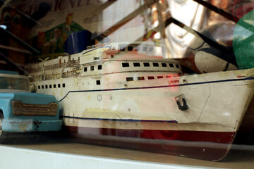 Close up picture of old vintage toys depicting transportation like plane, taxi, ship and others 