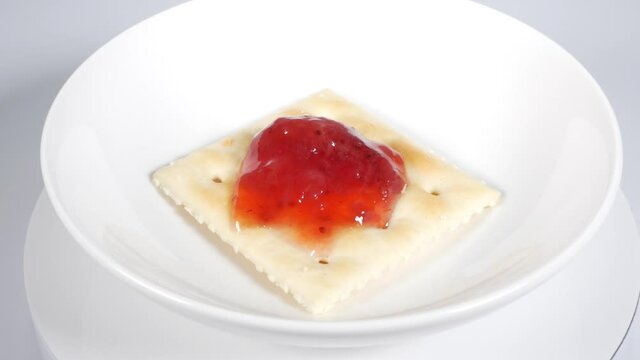 いちごジャムを乗せた四角いクラッカー

