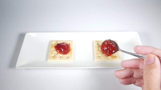 いちごジャムを乗せた四角いクラッカー
