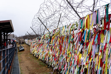 Paju, South Korea - April 10, 2019: Prayer ribbons tied on the fence at Imjingak Park near DMZ in Paju, South Korea. South Koreans tie ribbons with messages for their family members in the North.