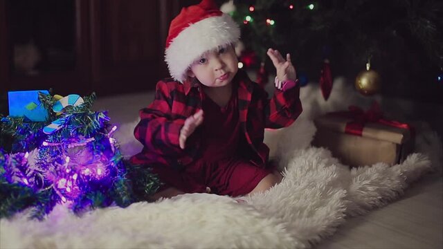 a child in red clothes is sitting waiting for the new year. the concept of celebrating Christmas at midnight. holiday costume