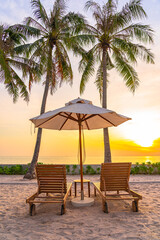 Umbrella and deck chair on tropical beach sea ocean at sunset or sunrise time