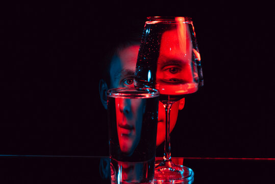 Fototapeta man looking through glass glasses of water with reflections and distortions
