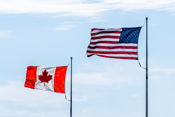 Buffalo, New York, USA - September 22, 2019: American and Canadian flags with blue sky in background. 