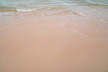 Fototapeta na wymiar Soft ocean wave on tropical sandy beach in summer background with copy space 