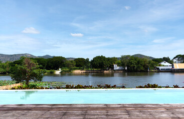 Fototapeta premium Landscape of the river Kwai Kanchanaburi Thailand Asia view in the morning with natural sunrise and clear clouds sky on the summer holiday, over the hotel swimming pool