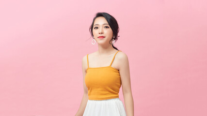 Asian young woman's half-length portrait on pink studio background.