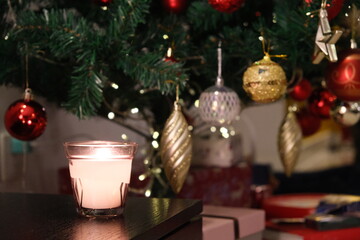 close up candle light and blurred Christmas tree 